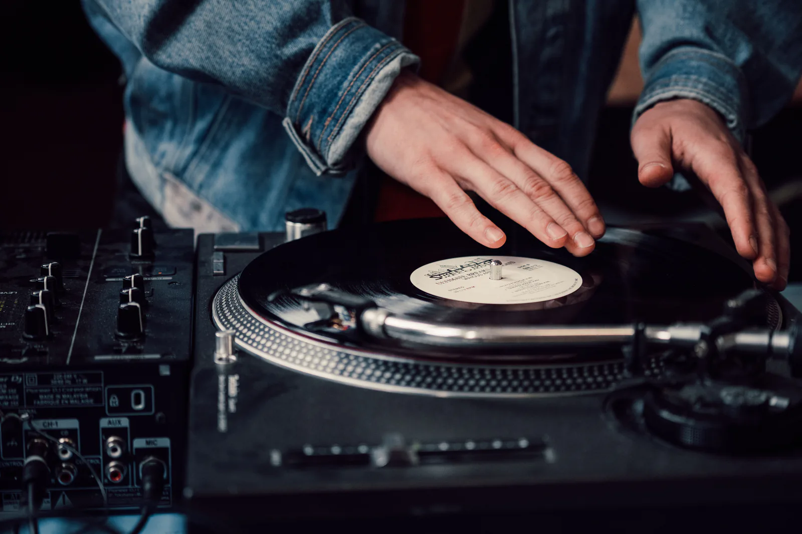 DJ mixing records under low studio light